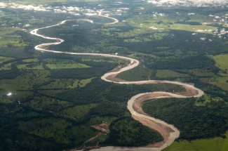 Meandering rivers create a dynamic landscape, depositing sand bars and eroding steep banks as they undulate across their floodplains.