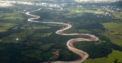 Meandering rivers create a dynamic landscape, depositing sand bars and eroding steep banks as they undulate across their floodplains.